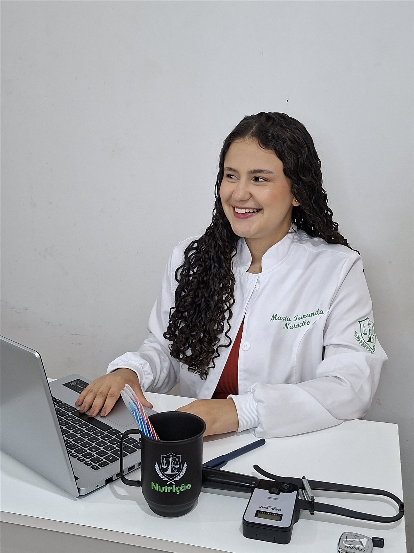 Nutricionista Maria Fernanda sorrindo em seu consultório